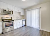 Thumbnail 9 of 13 - A kitchen with a stove, microwave, and cabinets at Pleasanton Heights, California