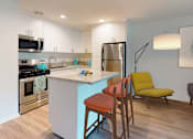 Thumbnail 10 of 13 - A kitchen with a blue island and a yellow chair at Rancho Los Feliz, Los Angeles, California