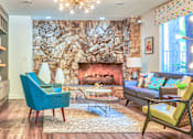 Thumbnail 1 of 13 - A living room with a stone wall and a fireplace at Rancho Los Feliz, Los Angeles, California