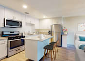 Thumbnail 4 of 10 - A kitchen with white cabinets and a blue island.