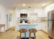 Thumbnail 5 of 10 - A kitchen with a blue island and stainless steel appliances.