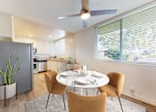 Thumbnail 8 of 14 - A dining room with a table set for two and a ceiling fan.