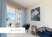 Thumbnail 17 of 24 - A living room with a large window, a sofa, a chair, and a table with a plant on it at Marina Harbor, California, 90292