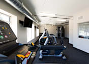 Thumbnail 3 of 19 - A gym with treadmills and a television mounted on the wall.
