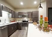 Thumbnail 9 of 19 - A kitchen with dark wood cabinets and stainless steel appliances.