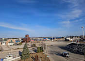 Thumbnail 17 of 19 - A view of a parking lot with a boat and a building in the background.