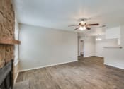 Thumbnail 14 of 27 - Living Room with Fireplace and Ceiling Fan at Bookstone and Terrace Apartments in Irving, Texas
