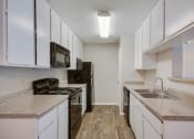 Thumbnail 12 of 27 - Model Kitchen at Bookstone and Terrace Apartments in Irving, Texas