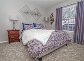 Thumbnail 10 of 37 - A bedroom with a bed, nightstand, and window at The Oasis apartments in Bossier City, LA