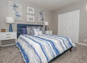 Thumbnail 12 of 37 - A bedroom with a bed, nightstand, and two lamps at The Oasis apartments in Bossier City, LA