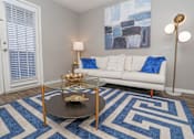 Thumbnail 4 of 37 - Spacious living room with pattern rug and off white couch at The Oasis apartments in Bossier City, LA