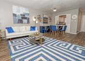 Thumbnail 2 of 37 - Model living room and dining area with couch and rug at The Oasis apartments in Bossier City, LA