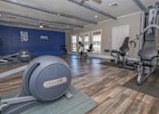 Thumbnail 22 of 37 - A gym with a blue wall and a variety of exercise equipment at The Oasis apartments in Bossier City, LA
