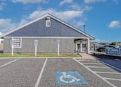 Thumbnail 20 of 37 - Parking lot with a handicap parking space in front of the leasing office at The Oasis apartments in Bossier City, LA