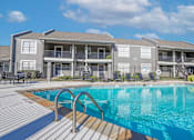 Thumbnail 1 of 37 - A swimming pool in front of apartment buildings at The Oasis apartments in Bossier City, LA