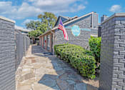 Thumbnail 5 of 23 - A stone pathway leads to a building with a sign that reads "The Bay.".
