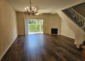 Thumbnail 3 of 11 - an empty living room with a fireplace and a chandelier