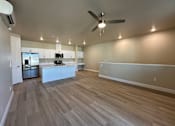 Thumbnail 10 of 13 - A spacious kitchen with a refrigerator, microwave, and oven.