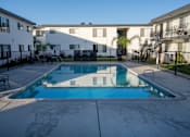 Thumbnail 11 of 25 - A swimming pool in a courtyard surrounded by buildings.