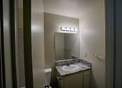 Thumbnail 25 of 25 - A bathroom with a sink, mirror, and toilet.