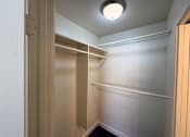 Thumbnail 18 of 25 - A white closet with a light on the ceiling.