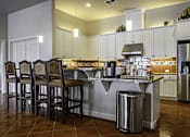 Thumbnail 7 of 18 - a kitchen with a large island with bar stools