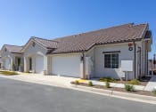 Thumbnail 2 of 18 - a home with a gray exterior and a white garage door