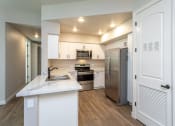 Thumbnail 6 of 18 - a kitchen with white cabinets and stainless steel appliances