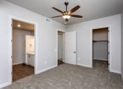 Thumbnail 9 of 18 - a bedroom with a ceiling fan and two doors