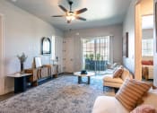 Thumbnail 3 of 18 - a living room with a ceiling fan and a door to a balcony