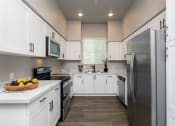 Thumbnail 7 of 18 - a kitchen with white cabinets and stainless steel appliances