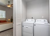 Thumbnail 15 of 18 - a bedroom with a ceiling fan and a washer and dryer