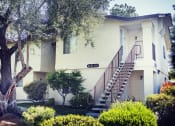 Thumbnail 4 of 32 - a house with a staircase and trees in front of it