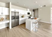 Thumbnail 2 of 3 - a large white kitchen with stainless steel appliances and a white island