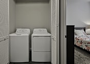 Thumbnail 18 of 18 - a laundry room with two washers and a dryer next to a bed