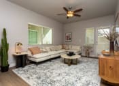 Thumbnail 12 of 13 - a living room with a couch and a ceiling fan