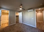 Thumbnail 2 of 13 - A room with a ceiling fan and a wall-mounted air conditioner.