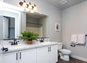 Thumbnail 13 of 18 - a bathroom with white cabinets and a white toilet