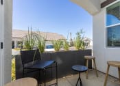 Thumbnail 16 of 18 - a small patio with two stools and two tables