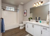 Thumbnail 14 of 18 - a bathroom with white cabinets and a white bathtub
