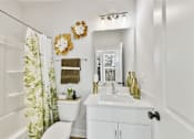 Thumbnail 8 of 13 - A white bathroom with a toilet, sink, and shower.