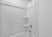 Thumbnail 9 of 49 - A white bathroom with a shower and a glass door.