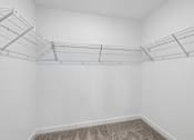 Thumbnail 12 of 49 - Empty room with white walls and a carpeted floor.