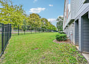 Thumbnail 16 of 16 - A black fence surrounds a green lawn in front of a building.