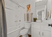 Thumbnail 7 of 12 - A white bathroom with a toilet, sink, and bathtub.