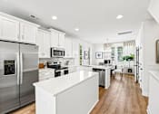 Thumbnail 4 of 16 - A modern kitchen with stainless steel appliances and white cabinetry.