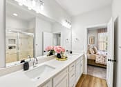 Thumbnail 11 of 16 - A bathroom with a white sink and a large mirror.