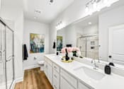 Thumbnail 10 of 16 - A bathroom with a white sink and a large mirror.