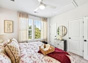 Thumbnail 9 of 16 - A bedroom with a large bed and a window with curtains.
