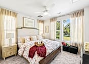 Thumbnail 8 of 16 - A bedroom with a large bed and a ceiling fan.